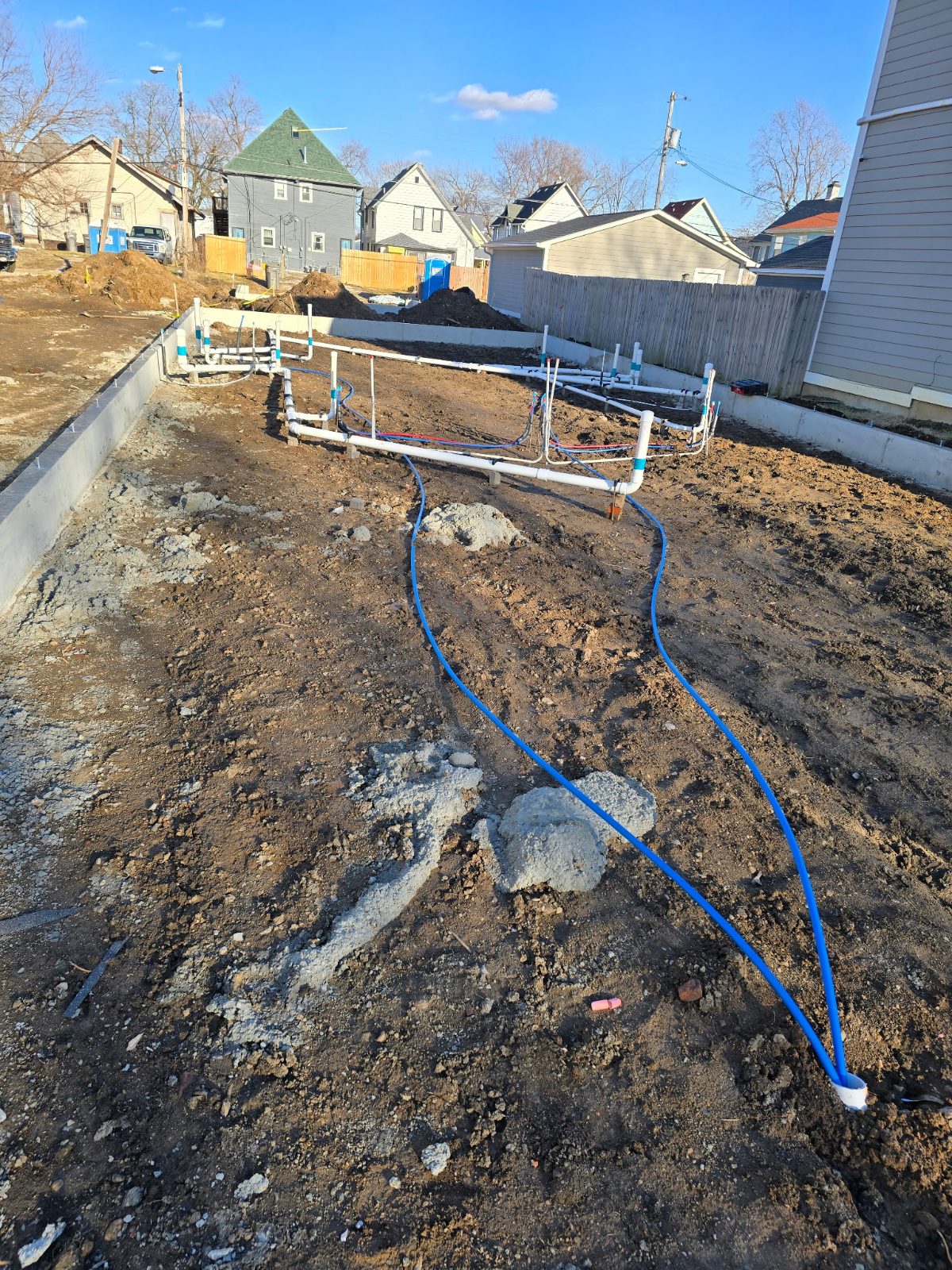 Under-slab plumbing rough-in laid out inside poured foundation walls