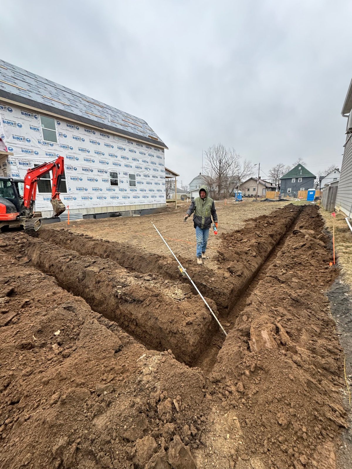 Crew member checking footing trench layout with a string line