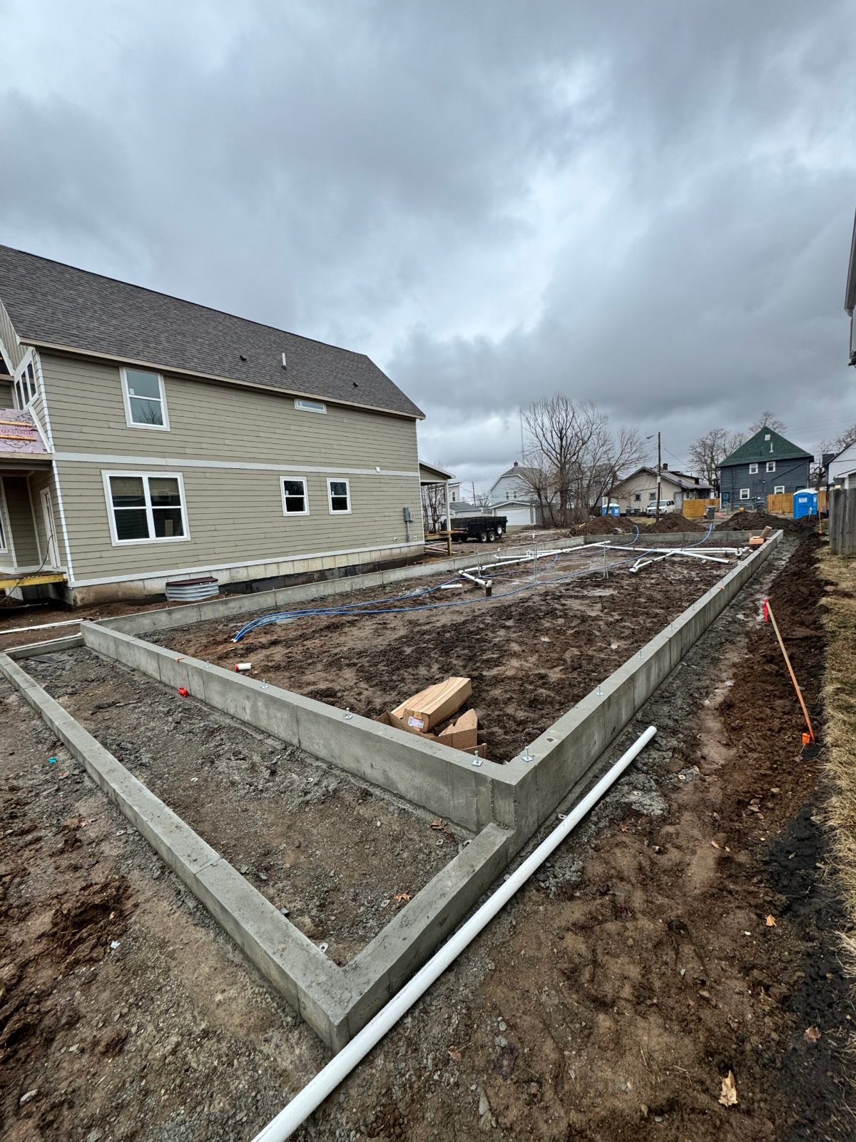 Finished concrete stem wall and footing forming a new foundation perimeter